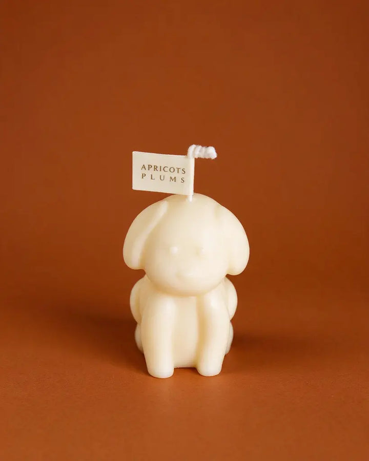 Cute ivory puppy-shaped scented candle made with natural plant wax, displayed as minimalist home decor 