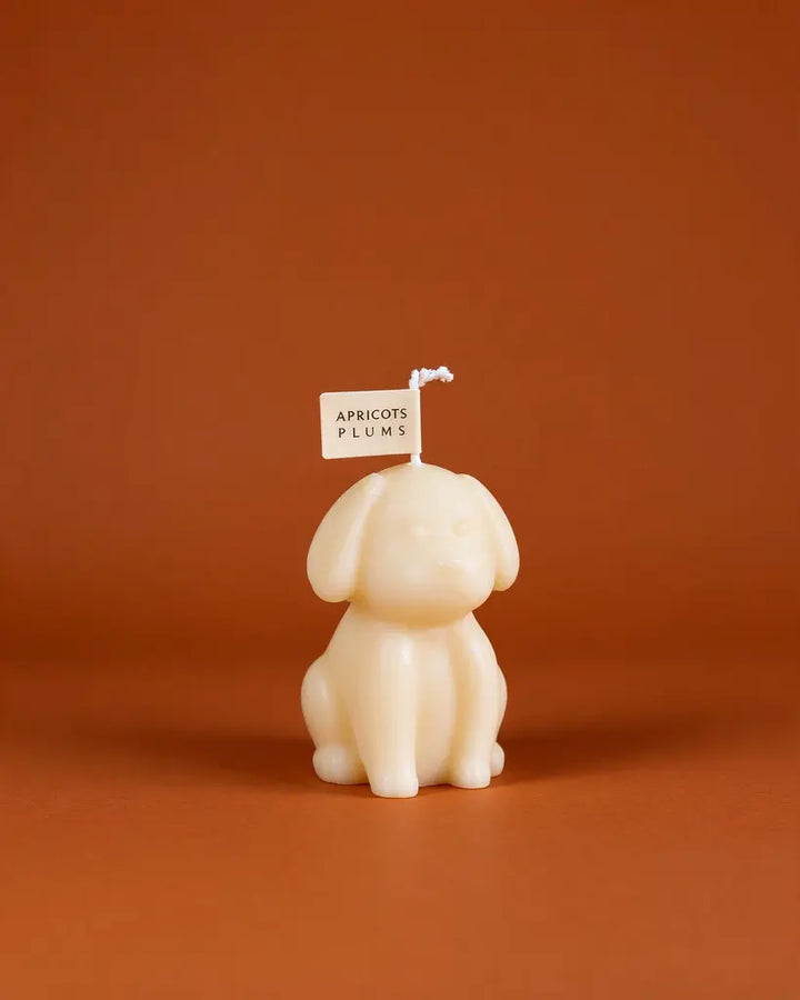 Cute ivory puppy-shaped scented candle made with natural plant wax, displayed as minimalist home decor 