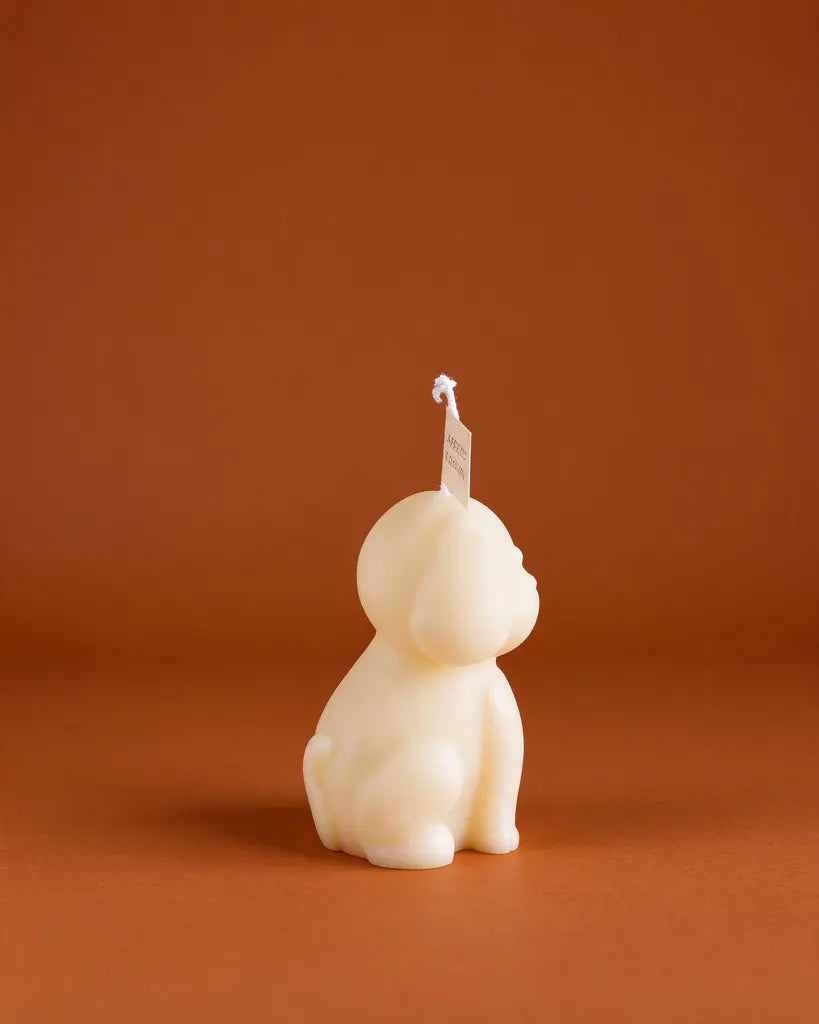 Cute ivory puppy-shaped scented candle made with natural plant wax, displayed as minimalist home decor 