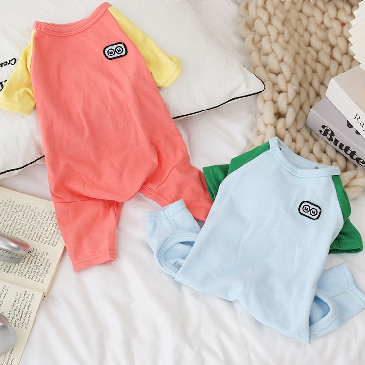 Colorblock pet outfits with robot eyes on a bed