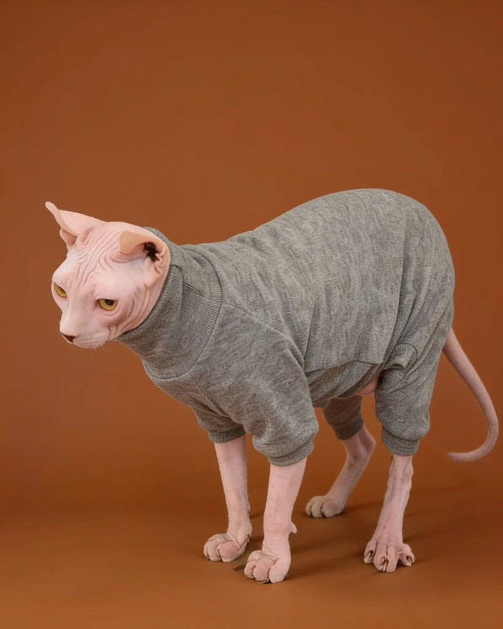 A hairless cat wearing a gray ribbed turtleneck pet onesie.