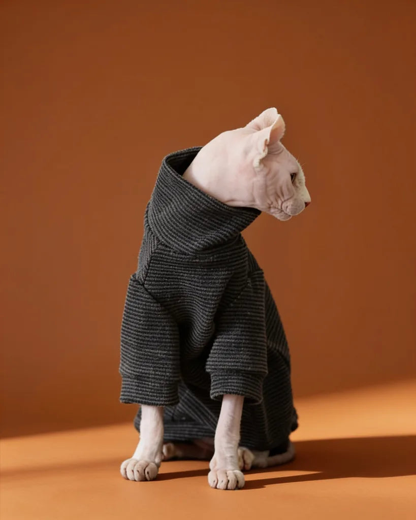 Sphynx cat wearing a soft black striped fleece onesie for fall and winter warmth