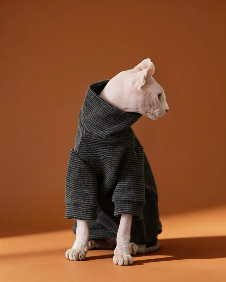 Sphynx cat wearing a soft black striped fleece onesie for fall and winter warmth