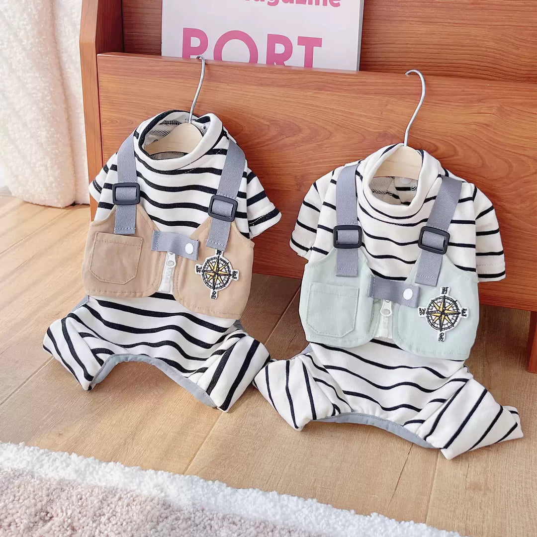 Two pet's outfits with suspenders hanging on a wooden shelf.