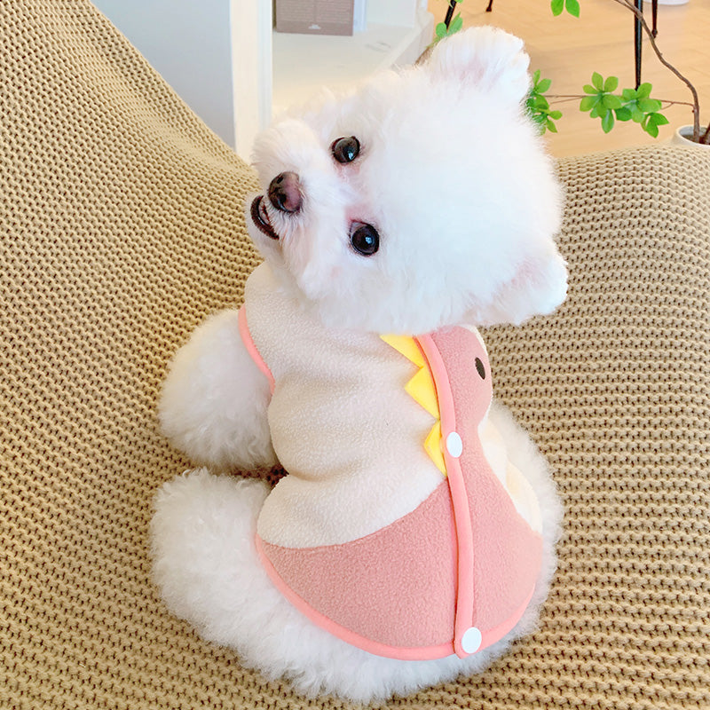 Puppy wearing cute button through pink dinosaur fleece vest.